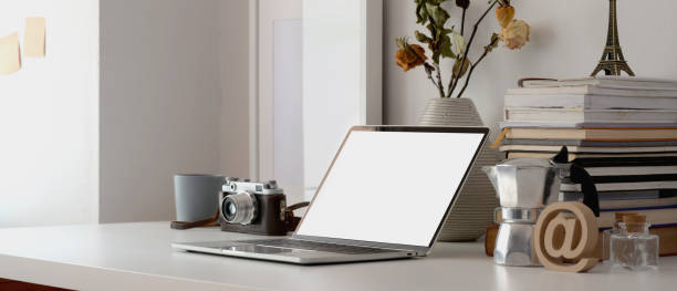 istock Minimal workspace with laptop computer, camera, office supplies and dry roses vase 1183864975