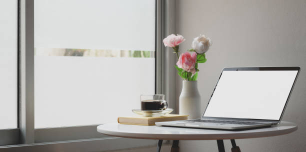 istock Modern workspace with laptop computer and flowers decorations on white table 1183864976