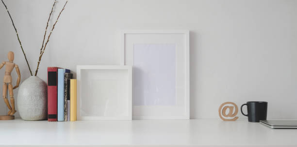 istock Minimal workspace with mock up frame and office supplies on white wooden table 1183864977