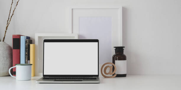 istock Minimal workspace with open blank screen laptop computer with office supplies and copy space 1183864992
