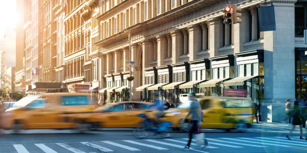 belebte straßenszene in midtown manhattan mit taxis und menschen in new york city - taxi new york city traffic busy stock-fotos und bilder
