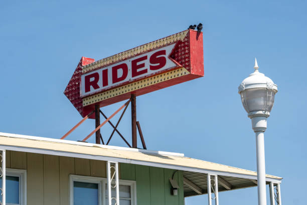 istock Two Birds Sit on a Lighted Arrow Sign Saying Rides 1183870194