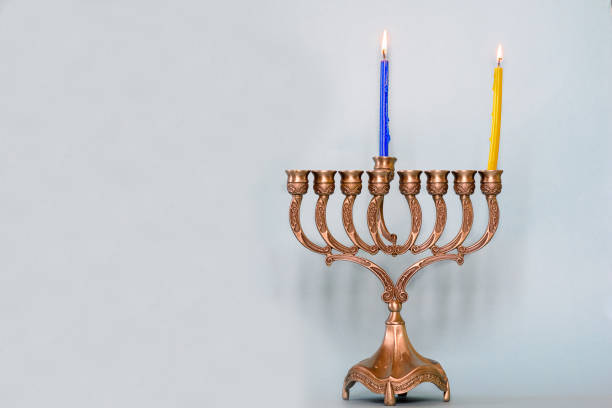 First day of Hanukkah with burning Hanukkah colorful candles in Menorah traditional Candelabra First day of Hanukkah with burning Hanukkah colorful candles in Menorah traditional Candelabra .Chanukkah-jewish holiday. Each night, another candle is added. Copy space for text. day 1 stock pictures, royalty-free photos & images