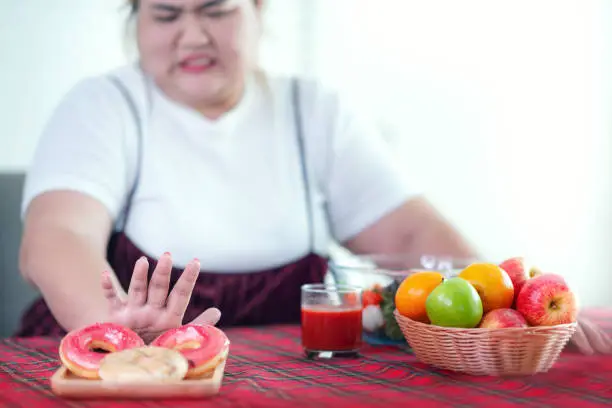 Photo of Asian fat girl stop to eat a fat food and junk food for her health and slim