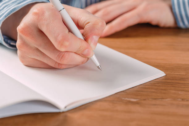 istock Beautiful Female hands write pen in a notebook of tasks and goals to work on a  table 1183877593