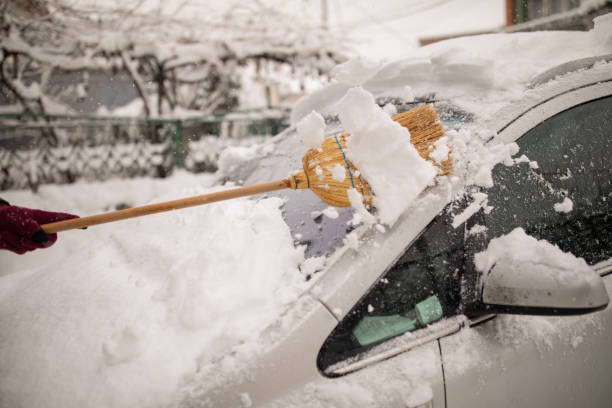 istock Man cleaning snow from car 1183879887