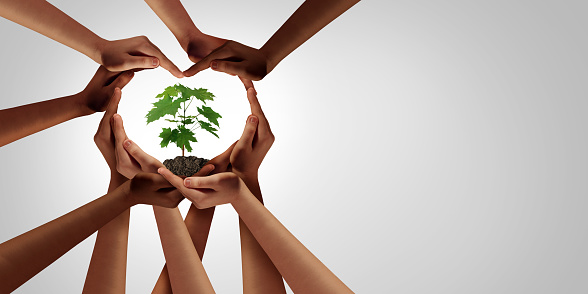 Earth day and earthday as group of diverse people joining to form heart hands connected together protecting the environment and promoting conservation and climate change issues as an image composite.