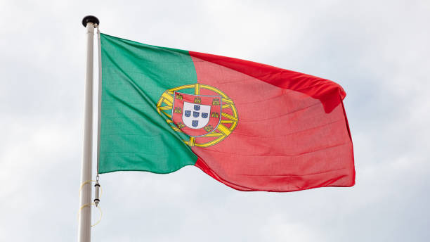 istock Portuguese flag waving against cloudy sky background 1183888103