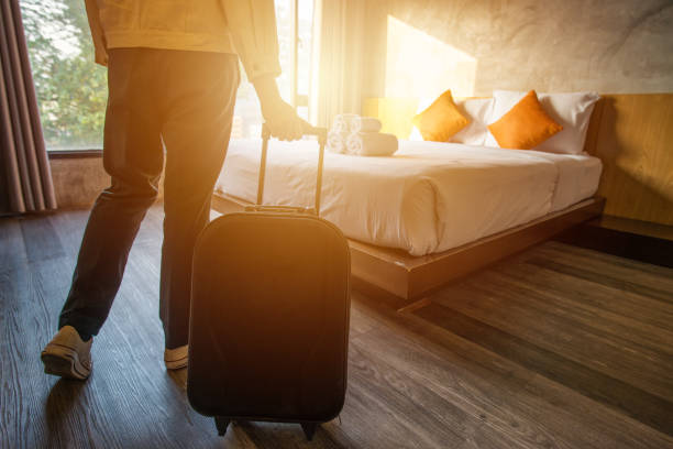 cropped shot of tourist woman pulling her luggage to her hotel bedroom after check-in. - hotel room bedroom hotel contemporary imagens e fotografias de stock