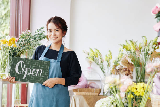 молодая азиатка открывает цветочный магазин - owner florist sign business стоковые фото и изображения
