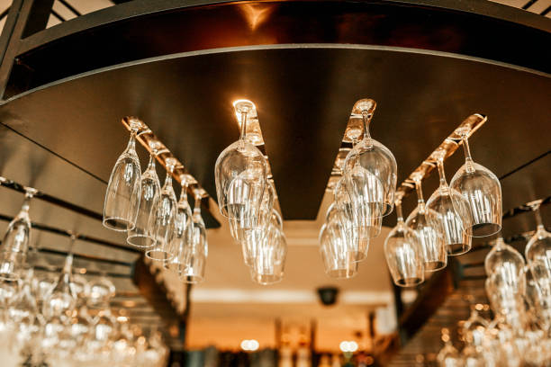 Cropped shot of wine glasses neatly arranged in a hanging wine rack in an empty bar