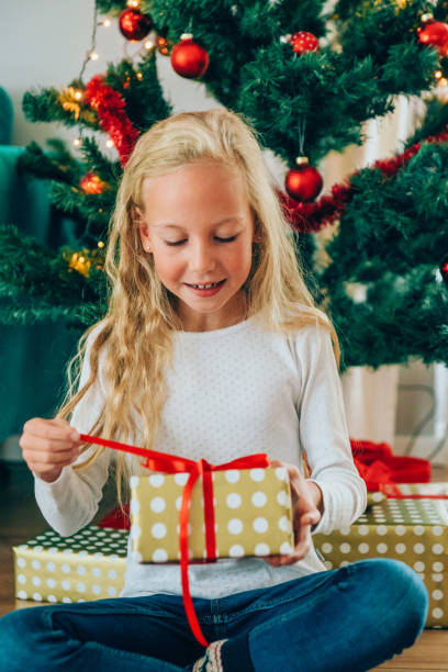 istock Cute girl opening christmas gift 1183896253