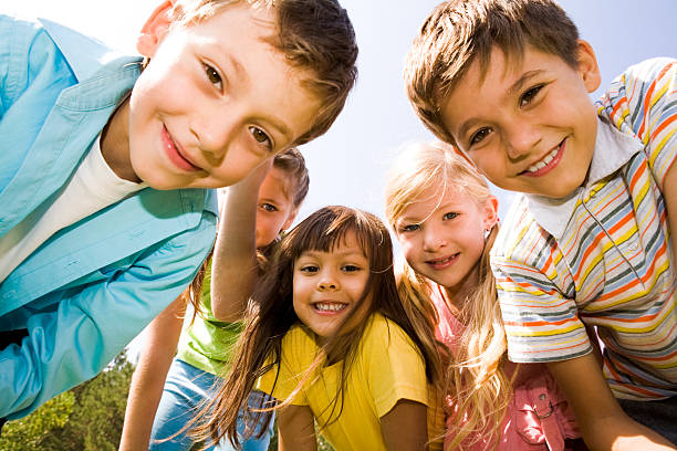 Happy friends Photo of happy girls with handsome lads in front smiling at camera cheerful children stock pictures, royalty-free photos & images