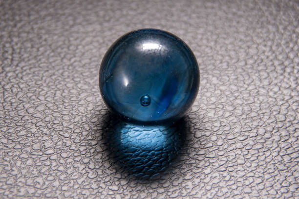 istock blue glass ball on black leather background 1183901270