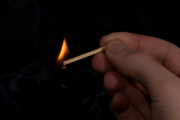 istock lit a match in his hand on a black background 1183901478