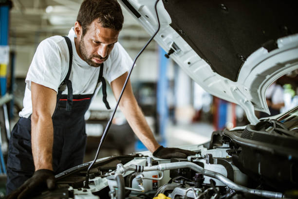 istock Young mechanic examining engine problems in auto repair shop. 1183903192