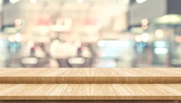 Photo of Empty step wood table top ( food stand ) with blur customer dining at cafe restaurant background bokeh light,Mock up for display or montage of product,Banner for advertising online media..