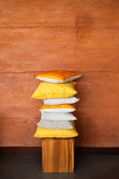 pillows on chair against orange wall. - scandic imagens e fotografias de stock