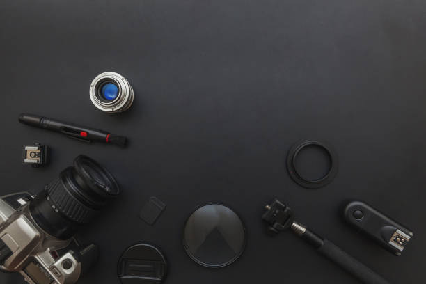 istock Photographer workplace with dslr camera system, camera cleaning kit, lens and camera accessory on dark black table background 1183912785