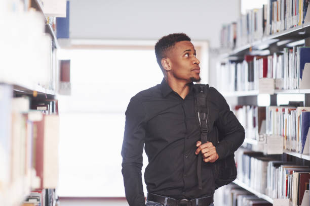 istock Going forward with backpack. African american man in the library searching for some books 1183914329