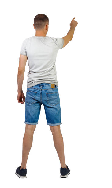 istock Back view of going handsome man in shorts pointing. 1183914686