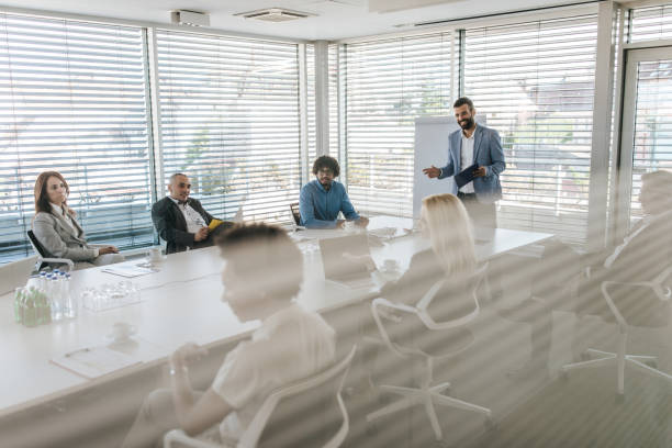 istock Male CEO communicating with his colleagues during a presentation in a board room. 1183921498