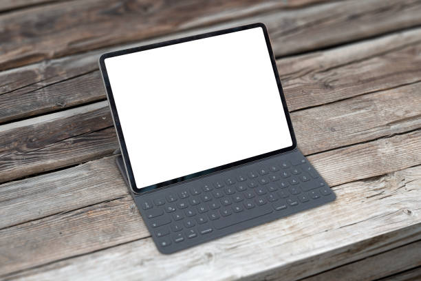 istock Tablet with keyboard on wooden table. Isolated screen for mockup. 1183925090