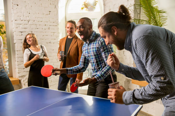istock Young people playing table tennis in workplace, having fun 1183925305