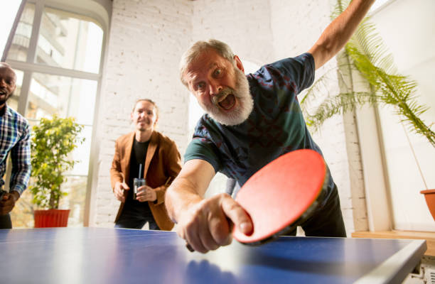 istock Young people playing table tennis in workplace, having fun 1183925330