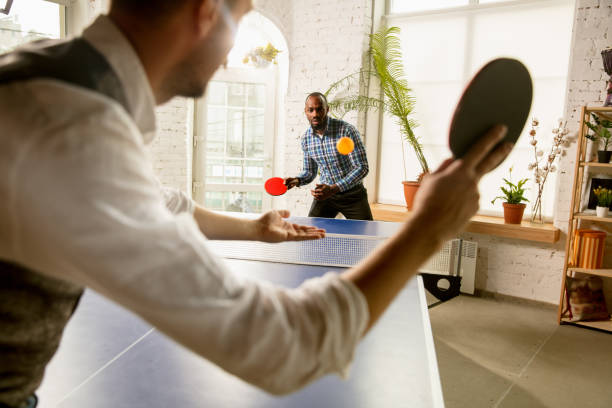 istock Young men playing table tennis in workplace, having fun 1183925372