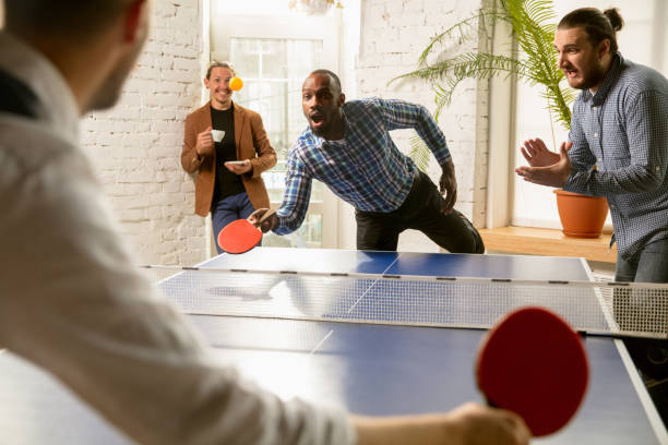istock Young people playing table tennis in workplace, having fun 1183925380