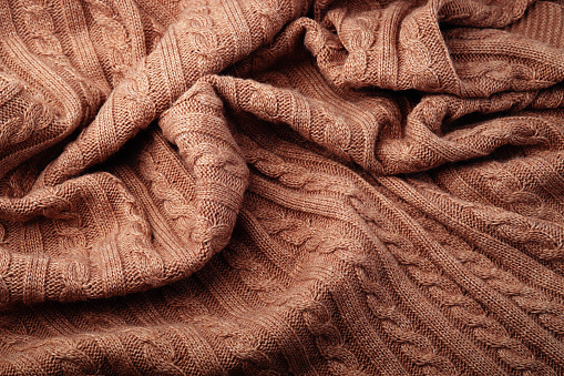 Folds of a knitted woolen blanket, top view