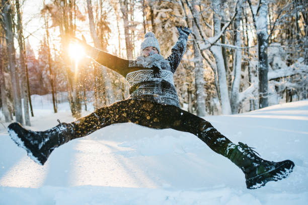 istock Young man having fun in snow outdoors in winter, jumping. 1183928367