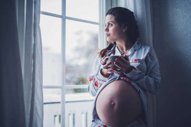 istock Serious pregnant female drinking coffee. 1183928668