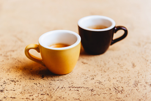 Two color coffee cups on light background copy space