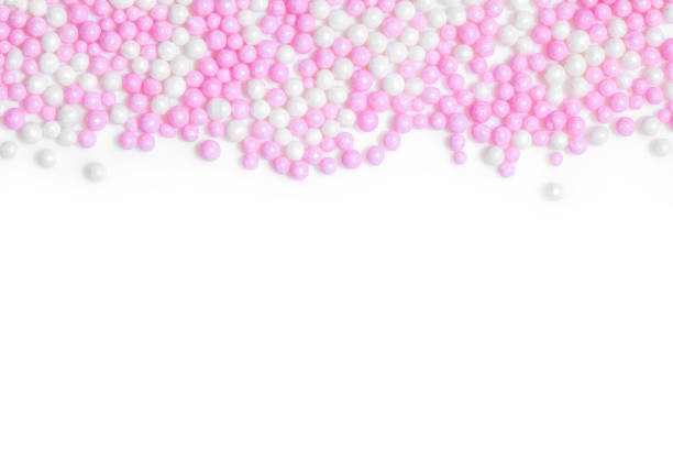 istock Pink and white sugar pearls on white background with copyspace 1183929132