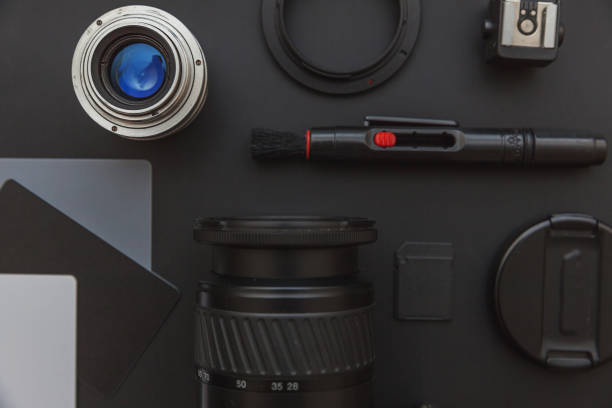 istock Photographer workplace with dslr camera system, camera cleaning kit, lens and camera accessory on dark black table background. Hobby travel photography concept Flat lay top view copy space 1183931891