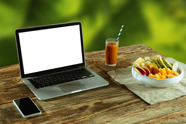 istock Blank laptop on a wooden table outdoors, mock up 1183933527