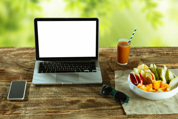 istock Blank laptop on a wooden table outdoors, mock up 1183933535