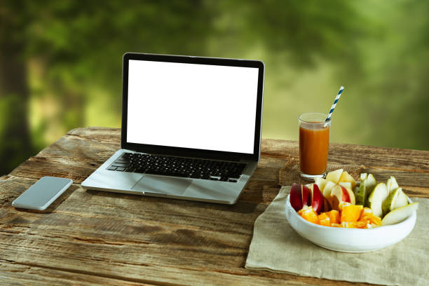 istock Blank laptop on a wooden table outdoors, mock up 1183933539