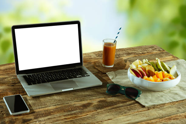 istock Blank laptop on a wooden table outdoors, mock up 1183933540