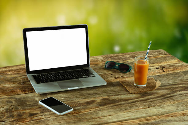 istock Blank laptop on a wooden table outdoors, mock up 1183933554