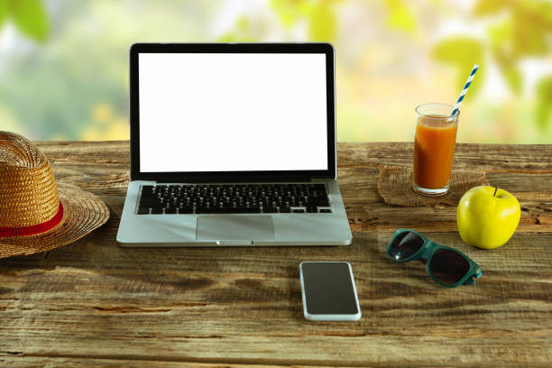 istock Blank laptop on a wooden table outdoors, mock up 1183933574