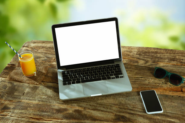 istock Blank laptop on a wooden table outdoors, mock up 1183933623