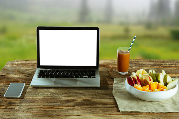 istock Blank laptop on a wooden table outdoors, mock up 1183933627