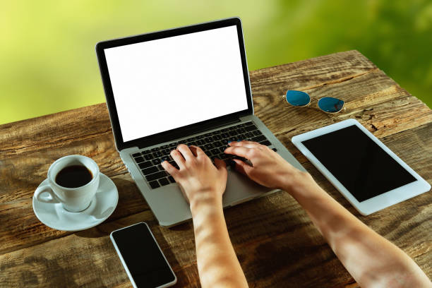 istock Blank laptop on a wooden table outdoors, mock up 1183933671