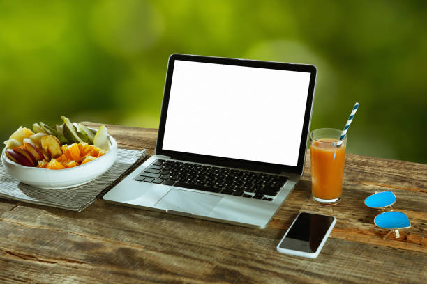 istock Blank laptop on a wooden table outdoors, mock up 1183933687