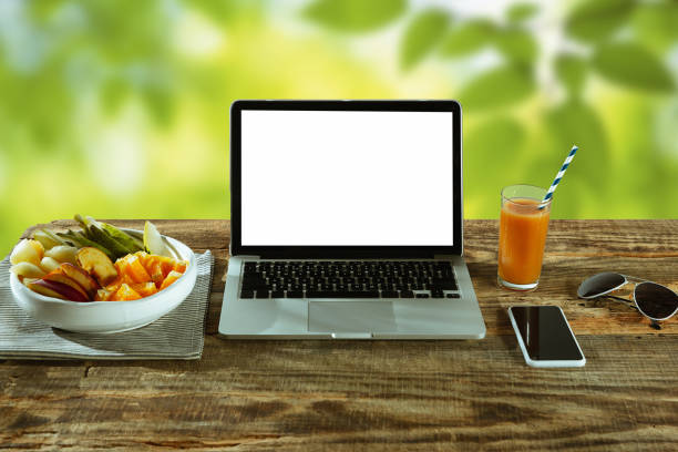 istock Blank laptop on a wooden table outdoors, mock up 1183933714
