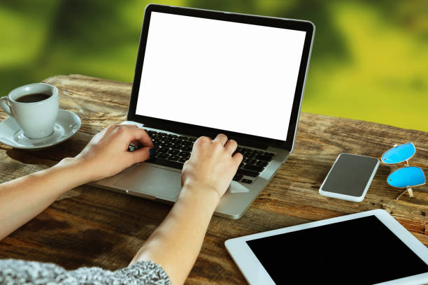 istock Blank laptop on a wooden table outdoors, mock up 1183933738