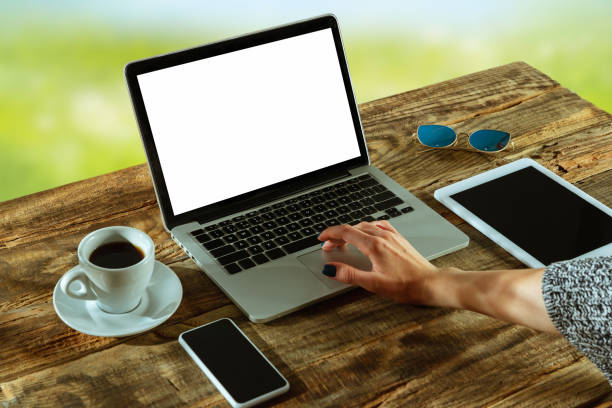 istock Blank laptop on a wooden table outdoors, mock up 1183933769